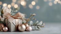 Elegant gift box with rose gold ribbon surrounded by festive ornaments and eucalyptus on blurred bokeh background.