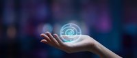 Human hand holding glowing digital hologram sphere with futuristic interface elements against blurred purple background for technology presentations.