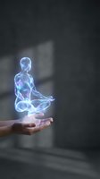 Holographic human figure in meditation pose floating above open palm representing mindfulness, spirituality and digital wellness technology concepts.