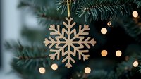 Wooden snowflake ornament hanging on Christmas tree with soft bokeh lights creating magical holiday atmosphere. Natural eco-friendly festive decoration.