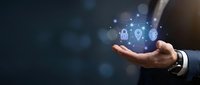 Businessman hand holding digital security icons with glowing padlock and shield symbols for data protection and cybersecurity solutions.