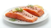 Fresh raw salmon fillets seasoned with black pepper and dill on white plate, ready for cooking. Healthy seafood protein for gourmet meals and culinary preparation.