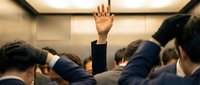 Business professional raising hand in crowded elevator during corporate meeting or conference networking event.