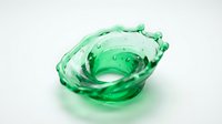 Green liquid splash forming dynamic wave shape with droplets on white background for beverage and freshness concepts.