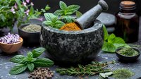 Traditional stone mortar with fresh herbs and colorful spices, surrounded by aromatic ingredients and essential oil bottles, perfect for natural medicine and culinary concepts.