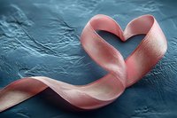 Pink satin ribbon forming heart shape on dark textured background, romantic symbol of love, care and awareness for Valentine's Day and special occasions.