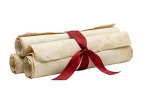 Rolled parchment papers tied with red ribbon bow, isolated on white background for diploma, certificate, award, and graduation design projects.