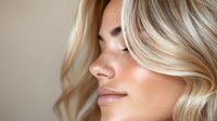 Young Caucasian woman with blonde wavy hair, natural freckles, and glowing skin shown in profile view against neutral background, expressing serenity and wellness.