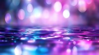 Magical purple and blue bokeh lights reflected on rippling water surface creating dreamy abstract background with blurred glowing circles and waves.