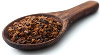 Aromatic clove buds dried spice in rustic wooden spoon on white background, macro food photography for cooking and culinary design projects.