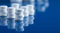 White medical pill bottles arranged in rows on blue background for pharmaceutical healthcare and medication storage concepts.