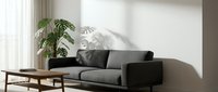 Modern gray upholstered sofa with black armrests positioned in bright minimalist living room with potted plant and wooden coffee table, suitable for interior design and home decor projects.