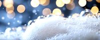 Soft white foam or snow texture with golden bokeh lights in background creating magical winter atmosphere. Festive blurred glowing backdrop.