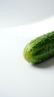 Fresh green cucumber with water droplets isolated on white background, suitable for food photography, healthy eating, organic produce, and culinary design projects.