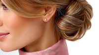 Young blonde woman with elegant updo hairstyle and pearl earrings in profile view on white background for beauty and fashion design projects.