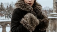 Woman in luxurious fur coat and muff enjoying winter outdoors. Elegant cold weather fashion and seasonal style for advertising campaigns and lifestyle content.