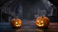 Carved jack-o-lantern pumpkins with glowing faces sit on wooden surface in spooky haunted house setting, perfect for seasonal decorations and Halloween marketing materials.