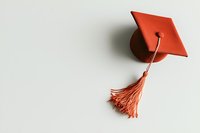 Red graduation cap with tassel on white background, minimalist academic achievement symbol for education and commencement designs.