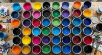 Colorful paint containers arranged in rows showing vibrant acrylic or watercolor paints for artistic projects and creative workshops.