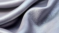 Elegant white leather texture with soft folds and natural grain pattern creating abstract waves and curves in monochromatic tones, macro photography closeup.