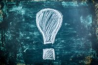 Chalk drawn exclamation mark on dark teal grunge chalkboard background with textured surface and eraser marks, expressing urgency or attention.
