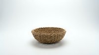 Empty woven seagrass basket bowl isolated on white background for home decor storage and organization projects.