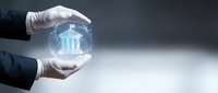 Hands in white gloves holding glowing holographic bank building symbol, representing financial security, digital banking technology, and investment protection for business concepts.