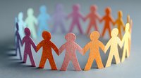 Colorful paper cutout figures holding hands in circle formation symbolizing unity, diversity, teamwork, and community connection.