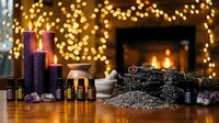 Cozy winter evening with essential oil bottles, knitted blanket and warm fireplace creating relaxing aromatherapy atmosphere for wellness and self-care.