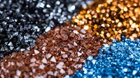 Diagonal stripes of glittering crystals in black, gold, brown and blue colors create luxurious festive background with sparkle and shine effect.
