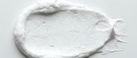 Creamy white cosmetic product swatch with textured surface isolated on white background, suitable for beauty and skincare packaging design.