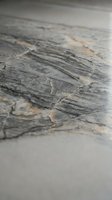 Weathered gray stone surface with natural cracks and erosion patterns showing geological texture and aging process for construction and design projects.