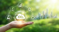 Hand holding CO2 carbon dioxide emission reduction concept with green energy icons and sustainable city skyline for environmental protection.