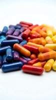 Colorful pharmaceutical capsules and pills scattered on white background for medical healthcare and supplement industry concepts.