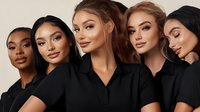 Group of five diverse young women wearing black polo shirts posing together against neutral background for corporate, team, or fashion marketing campaigns.