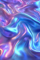 Holographic iridescent fabric with flowing waves and folds in blue and pink colors creates mesmerizing abstract background with metallic shimmer effect.