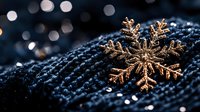 Golden snowflake decoration on dark knitted fabric with bokeh lights background creates magical winter holiday atmosphere. Perfect for seasonal designs.