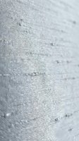 Close-up of white linen fabric texture with visible weave pattern and natural fibers. Suitable for textile, interior design, and material reference projects.