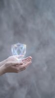 Hands holding glowing transparent shield symbol representing cybersecurity protection and data safety in digital technology concept.