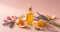 Natural honey and lavender essential oil skincare products with dried flowers and honeycomb on pink background for spa wellness and aromatherapy treatments.