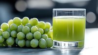 Fresh green grape juice in glass with bunch of ripe grapes on wooden table against dark background with bokeh lights. Natural healthy beverage concept.