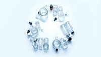 Overhead view of clear glass containers and bottles arranged in circle on white background, isolated for packaging and product design use.