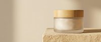 Luxury skincare jar with gold lid on natural stone platform, cosmetic product for beauty and wellness branding.