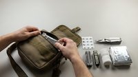 Military tactical first aid kit with medical supplies and emergency equipment for outdoor survival and combat preparedness.