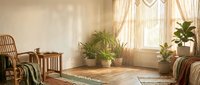 Cozy boho living room interior with wicker furniture, houseplants, warm sunlight streaming through curtains, natural textures and earth tones for home decor.