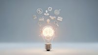 Glowing light bulb with business icons floating above representing innovation, creativity, and entrepreneurial ideas for startup success and growth.