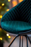 Luxurious teal velvet chair detail with quilted pattern against blurred bokeh lights background, modern furniture design element for interior decor photography.