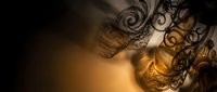 Ornate metal decorative elements casting intricate shadows on warm golden surface creating dramatic lighting effects for luxury interior design projects.
