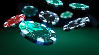 Casino poker chips scattered on green felt table with dramatic lighting and shallow depth of field creating atmospheric gambling environment.