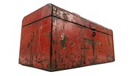 Vintage red metal trunk with weathered patina and distressed surface, showing rust and wear marks from decades of use and storage.